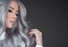 Comment passer de cheveux blonds au gris : Guide étape par étape femme aux cheveux gris ondulés, coupe moderne et élégante sur fond noir