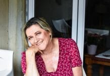 a woman sitting at a table with a smile on her face