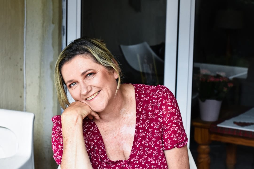 a woman sitting at a table with a smile on her face