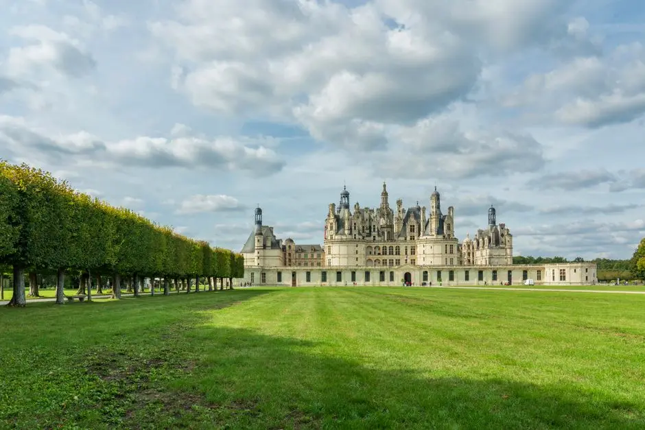 vetements-grande-taille-pas-cher-ou-acheter-2 Château de Chambord stands grandly under a blue sky, surrounded by lush gardens.