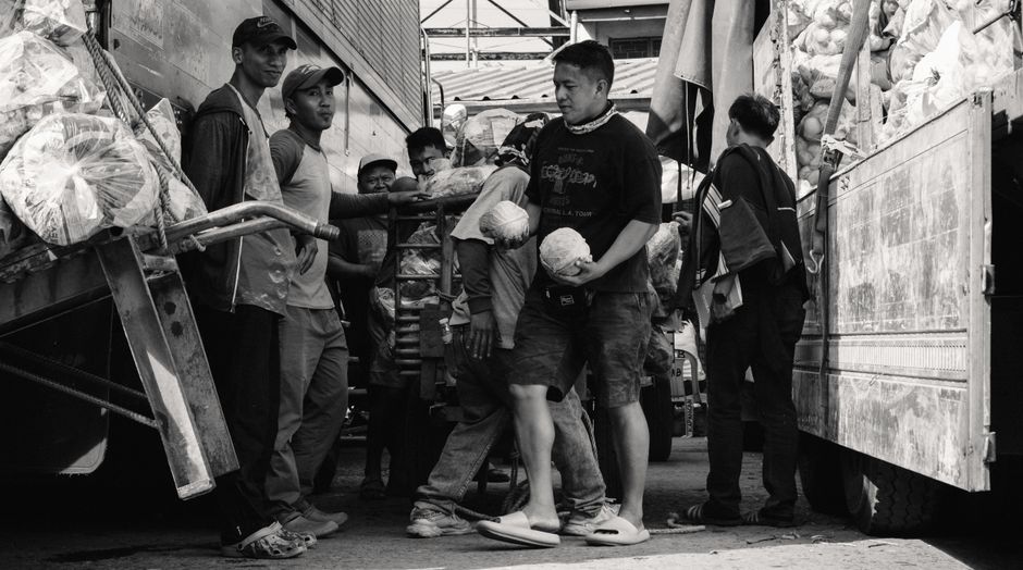 Porters working in a busy market, captured in black and white for a classic look.
