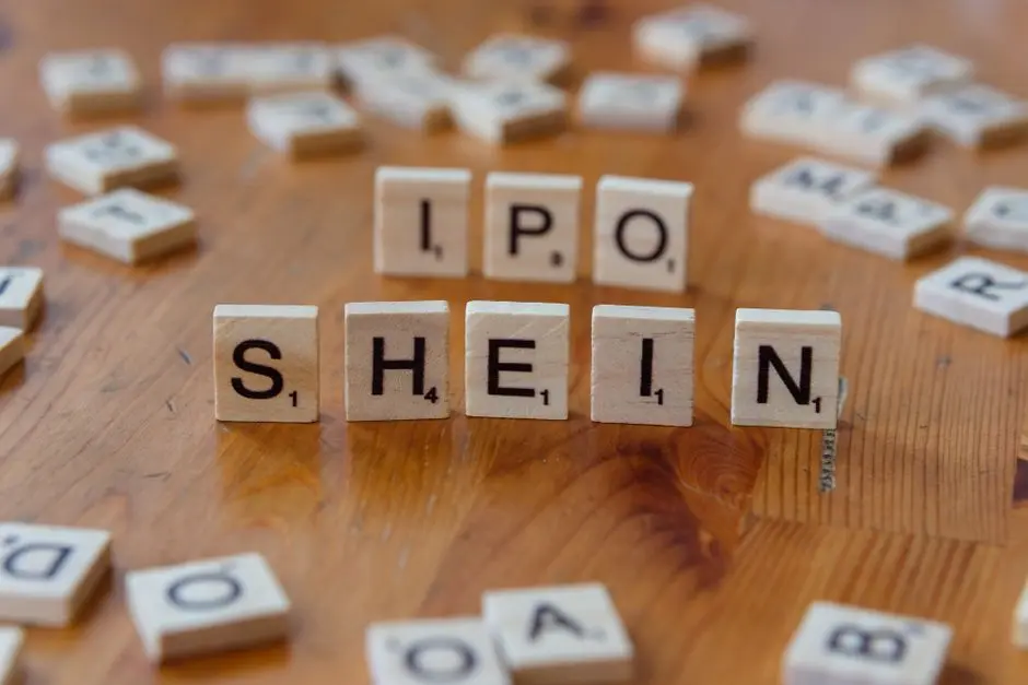 robe-petite-taille-shein-coupes-moins-20-euros Creative representation of Shein's IPO using letter tiles on a wooden surface.
