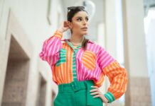 A woman wearing a colorful shirt and green pants